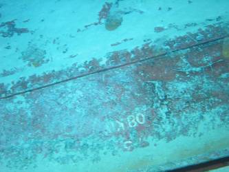 Large section of hull in debris field with "08KO" painted on plating